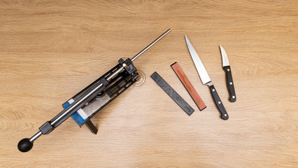 Close up of professional knife sharpener system fix angel 4 stones and 2 knifes on wooden table,...