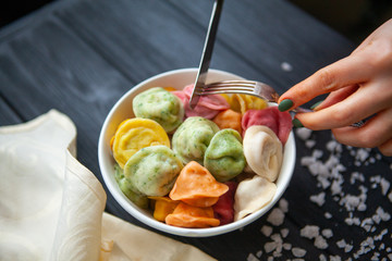 cooked dumplings of different colors in a white plate