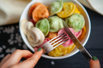 cooked dumplings of different colors in a white plate