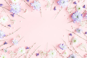 Flowers composition. White and purple flowers on pink background. Spring concept. Flat lay, top view, copy space