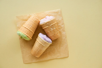 Various ice cream in waffle cups on a light background