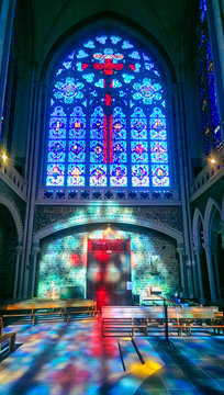 Red cross, and blue reflections of the stained glass windows of the Basilica of Notre-Dame de Pontmain, France.
