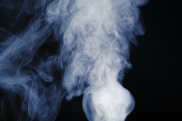 Aromatherapy. Essential oil aroma diffuser humidifier diffusing water articles in the air. Electric ultrasonic device emitting atomized water droplets against black background with copy space.