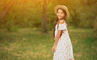 Smiling Teen Spinning in White Dress in Park. Girl Smiles to Camera, Wind Blows her Dress in Sun Light.