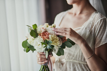 bouquet in hands of the bride, woman getting ready before wedding ceremony