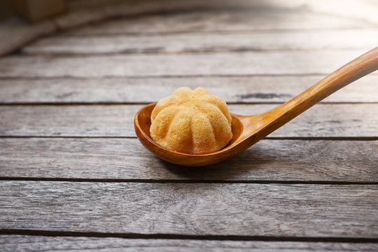Kuih Bahulu or Baulu served in a wooden spoon.  Kuih Bahulu is a must have food during festive season such Hari Raya Aidilfitri