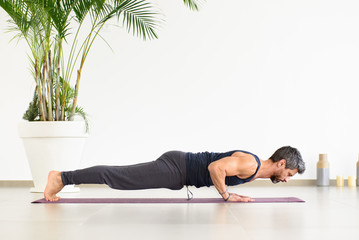 Fit man doing Yoga chaturanga push-ups