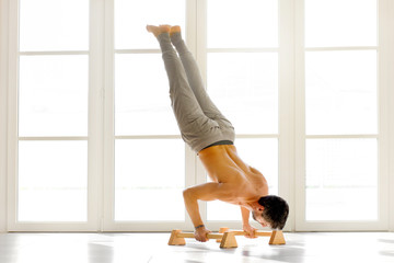 Man doing handstand push ups on bars