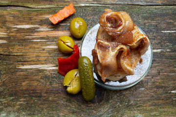 Tipica tapa española de oreja de cerdo frita con encurtidos y aceitunas para bares