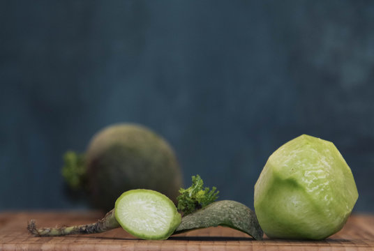 Peeled tuber sweet green margelan radish on a background of unpeeled