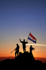 Three armed soldiers with the Croatian flag