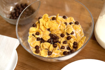 Tasty Corn Flakes In Bowl With Milk. Wooden Background With Napkin, Place For Text, Top View