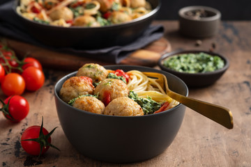 Pasta with meatballs and spinach with tomato sauce.