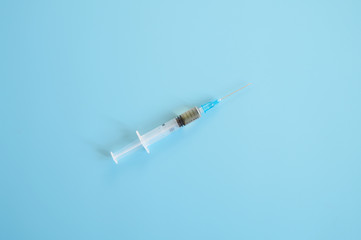 syringe with injection vaccine on a blue background. medicine plastic disposable vaccination...