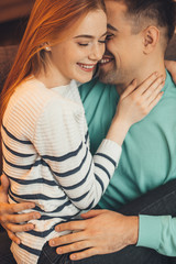 Red haired caucasian girl with freckles is held by her lover during a warm morning together