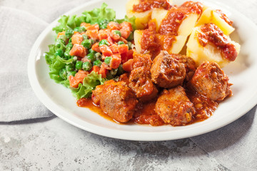 Braised pork meat stew served with potatoes