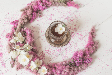 Flowers composition. circle made of pink flowers with a glass of tea on a white background. Top view, flat lay.