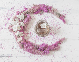 Flowers composition. circle made of pink flowers with a glass of tea on a white background. Top view, flat lay.