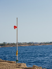 Fototapeta premium Red flag with the sea, Signal warning. Storm warning.