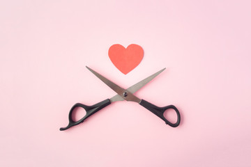 Scissors with red heart top view on pink background. Concept of divorce. Divorce proceedings, law, court, family break, pain