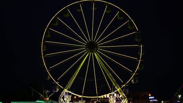 View of amusement park at night. Colorful ferris wheel in luna park