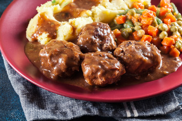 Roasted meatballs in dark sauce with mashed potatoes