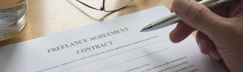 Reading a contract. Freelance agreement. A contract on the table.