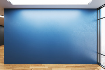 Empty spacious room with blank blue wall.