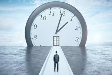 Businessman looking on clock with door