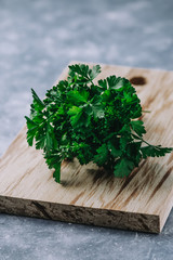 Parsley closeup. Green fresh garden herbs for culinary closeup on wooden table, top view. Arugula, parsley, dill, spinach, lettuce home planted overhead