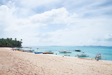 Obraz premium Beautiful landscape with tropical white sand beach with fishing boats. Siargao Island, Philippines.