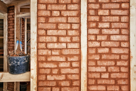 Adobe bricks filling the compartments of the framework of an eco-house under construction