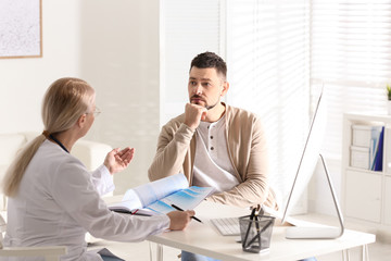 Doctor consulting patient at desk in clinic