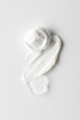 Obraz premium Top view of cosmetic cream brushstrokes and gel on grey background