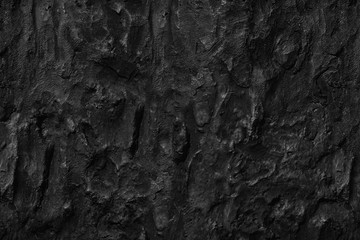 Dark aged shabby cliff face volcanic hillside. Coarse, rough gray volcanic stone or rock texture of...