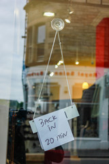 sign back in twenty minutes on the glass of a store that reflects the building opposite
