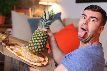 Man against mixing pizza and pineapple 