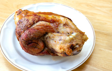 Dry baked leg pork without fat in white dish on brown wooden table