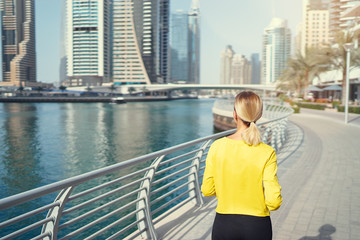 Fototapeta na wymiar Healthy lifestyle. Jogging outdoors. Young woman exercising on city embankment.