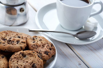 Top Closeup photo of sweet breakfast or snacks. Chocolate and vanilla cookies and cup of black coffee