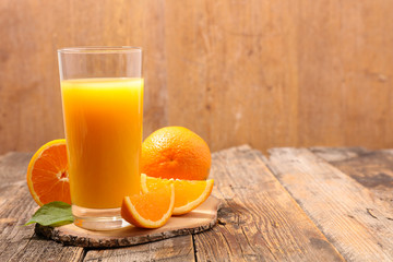 orange juice in glass on wood background