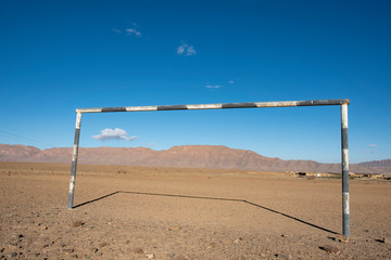black and white soccer goal on a gravel field in the mountains of Morocco