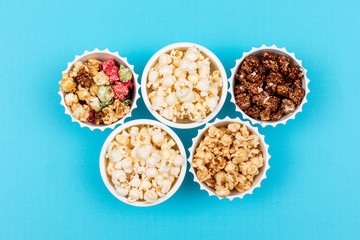 Fototapeta na wymiar Top view of popcorn in bowls on blue background horizontal