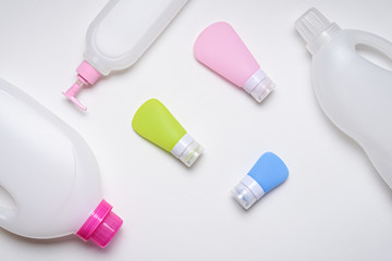 top view household plastic bottles and multicolored tubes on white background