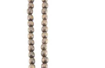 Two strands of dark brown wooden beads extend vertically on a white isolated background, on the left according to the rules of the third. Good quality. Unusual abstraction