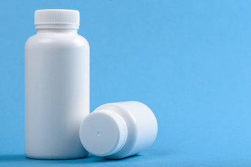two white medical plastic bottles on blue background