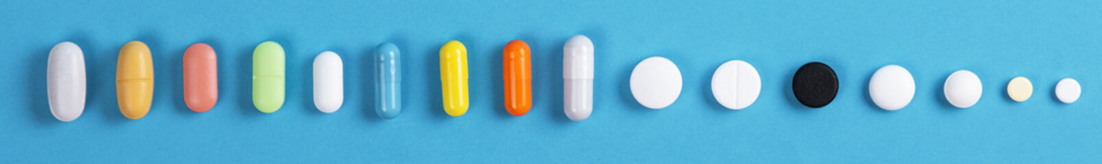 different colored tablets in row on blue background for banner