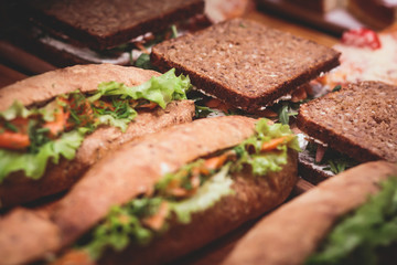 Beautifully decorated catering banquet table with different food snacks and appetizers with sandwich, on corporate christmas birthday kids party event or wedding celebration