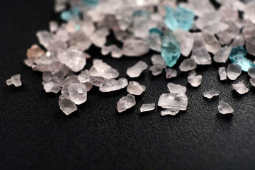 scattered multi-colored crystals of sea salt on a black background