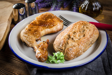 Fried chicken leg with bread roll.